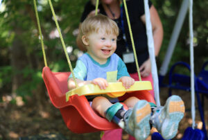 William William, a young boy who receives Summit DD EI Services, on a swing.