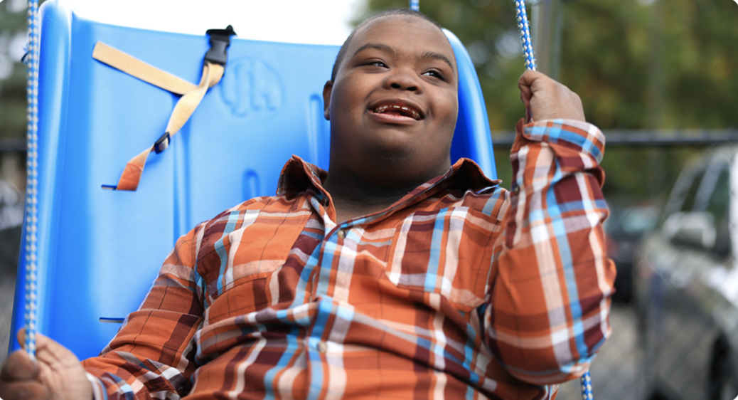 Travis, a young man who receives Summit DD services, on a swing.
