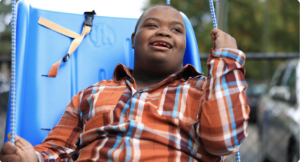 Travis, a young man who receives Summit DD services, on a swing.