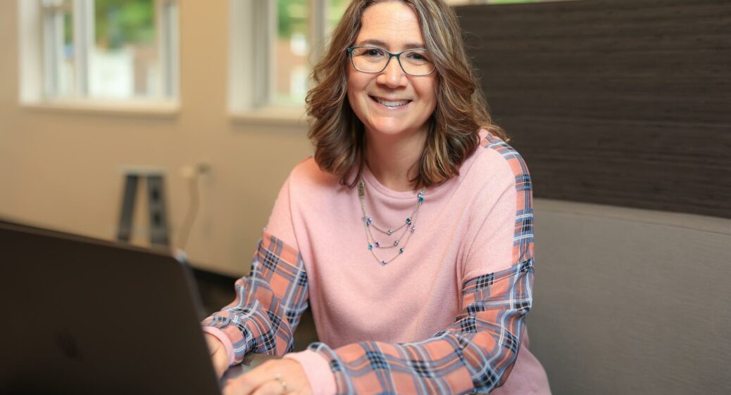 Smiling woman looking up from her laptop